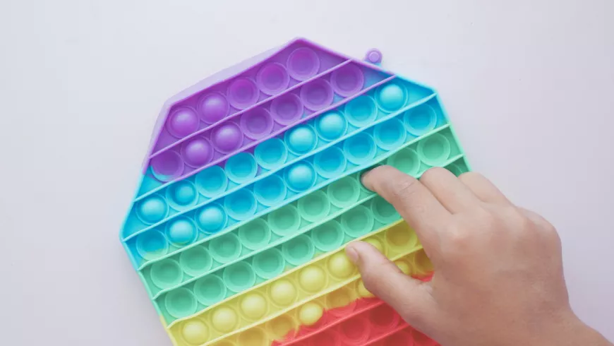 a hand playing with a fidget toy 