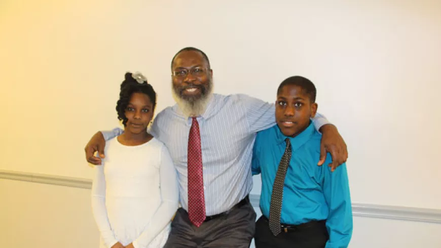 Student Engagement Grant receiver Fitzroy Lewis poses with his two children