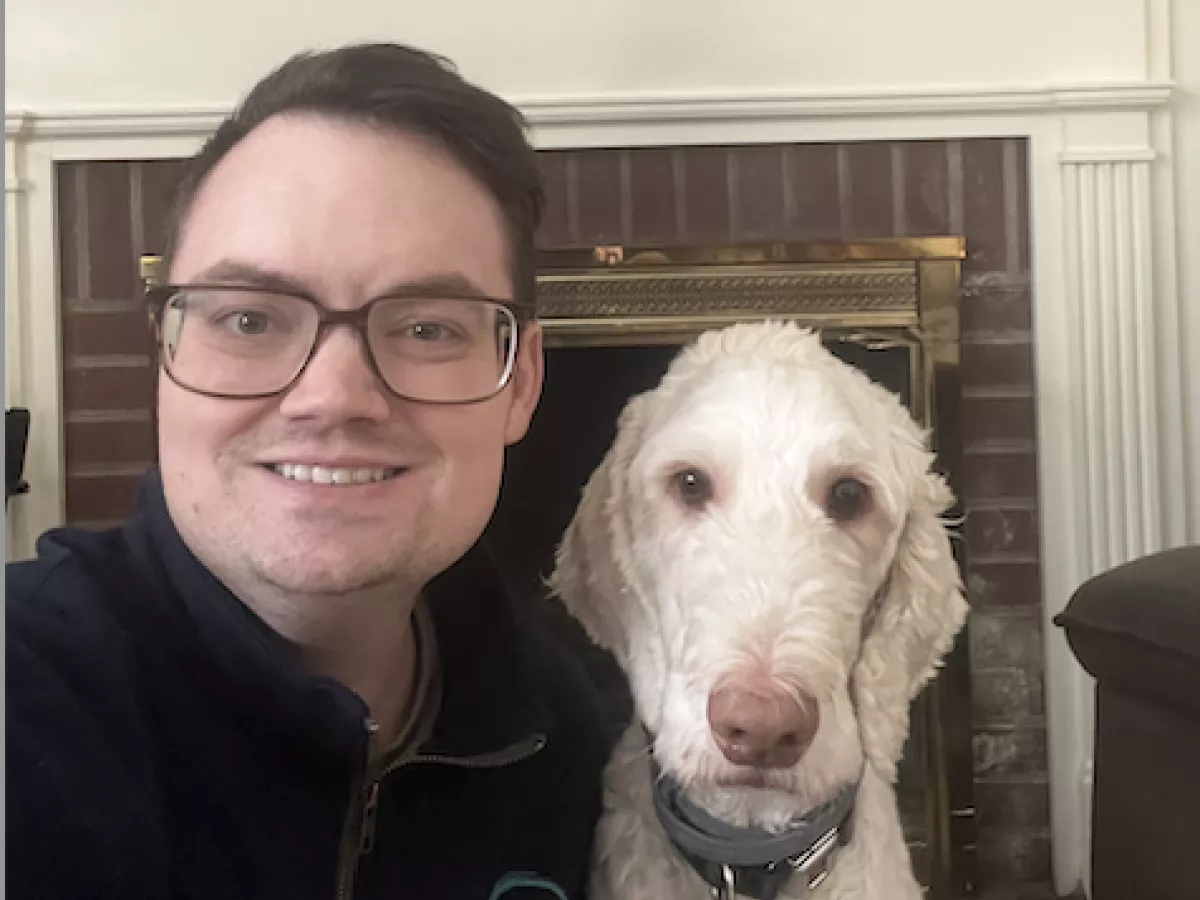 student Rich Carmey smiling next to his dog