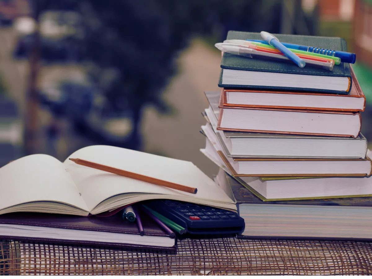 a stack of textbooks next to an open notebook