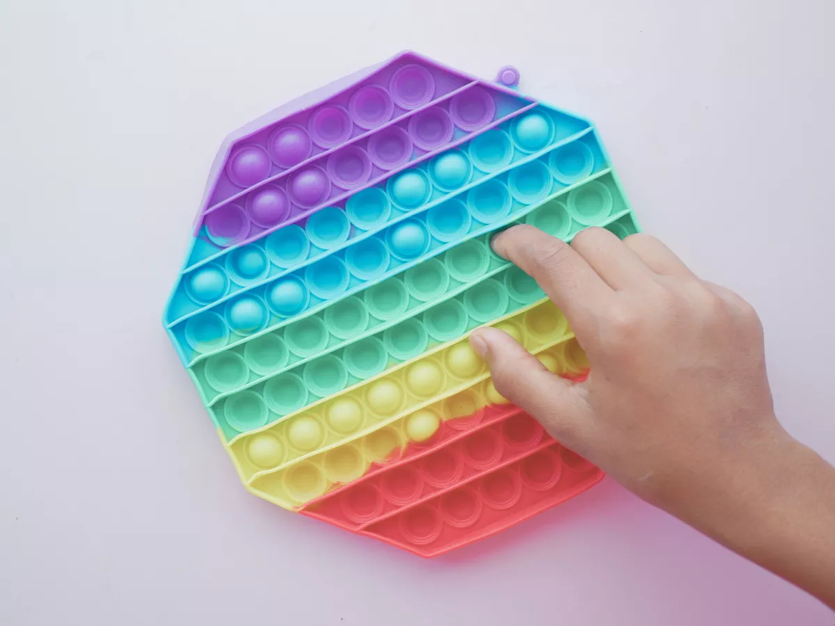 a hand playing with a fidget toy