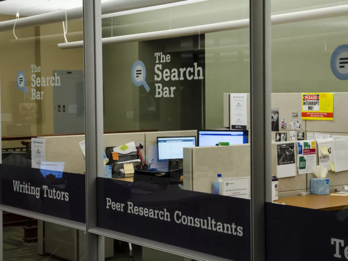 Glass paneled room with The Search Bar written on outside of glass and two people visible inside