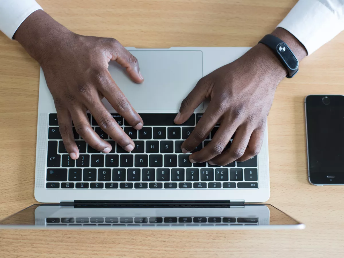 Hands type on a laptop