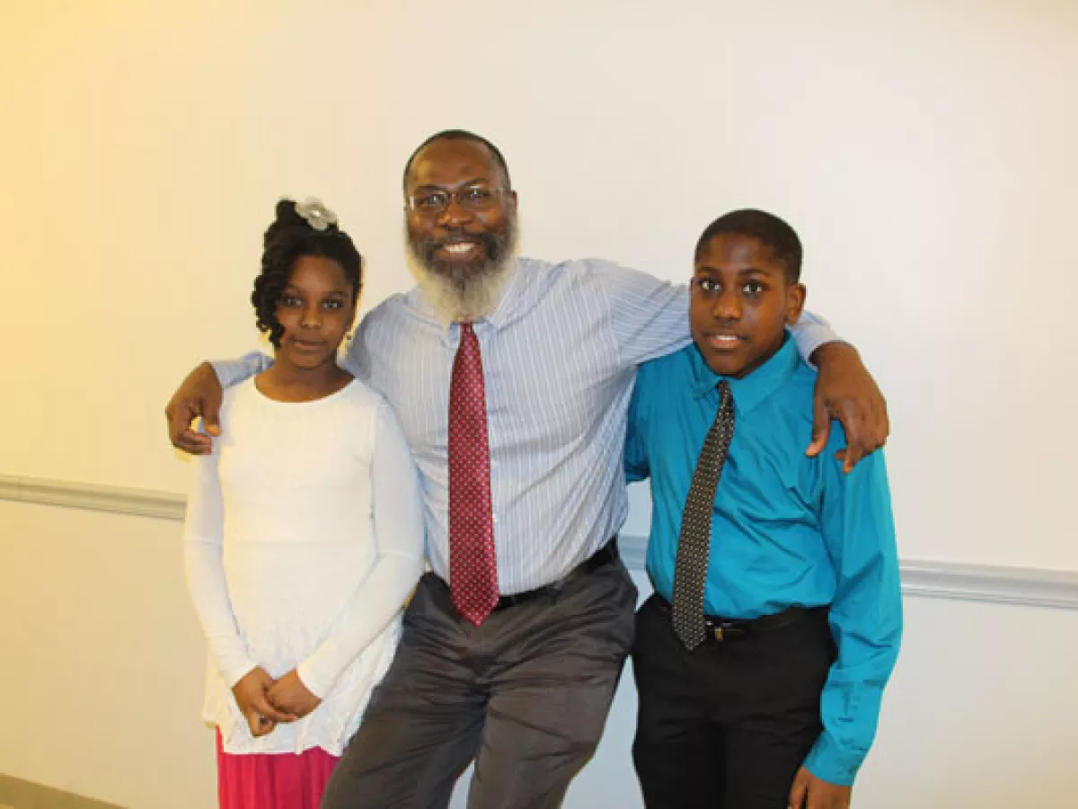 Student Engagement Grant receiver Fitzroy Lewis poses with his two children