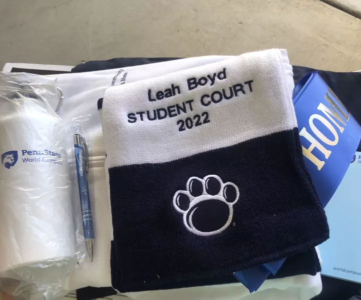 Assortment of Penn State items, including a towel with the Penn State paw and embroidered text that says, "Leah Boyd, Student Court 2022"