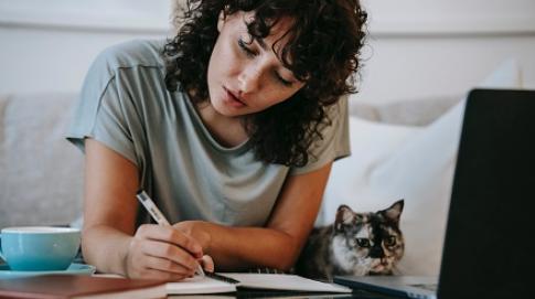 Woman studying next to cat